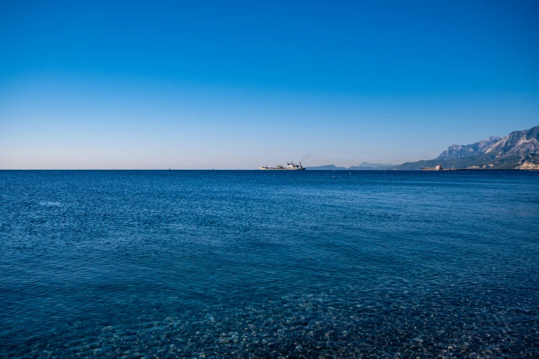 a boat floating on the water near some mountains