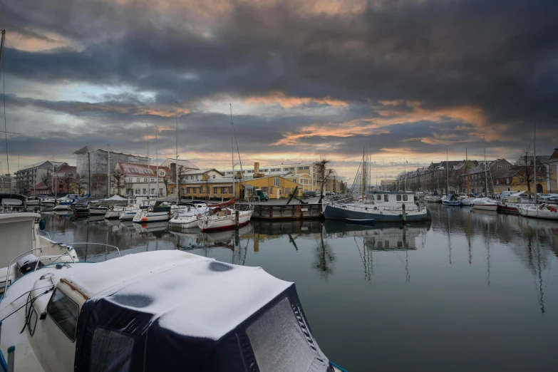 a dock with boats covered in snow at dusk