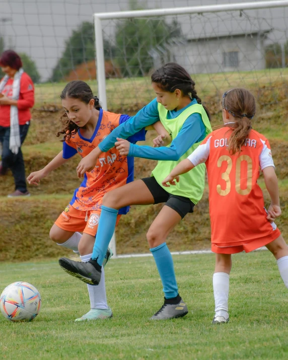 children in uniforms are playing soccer on a field