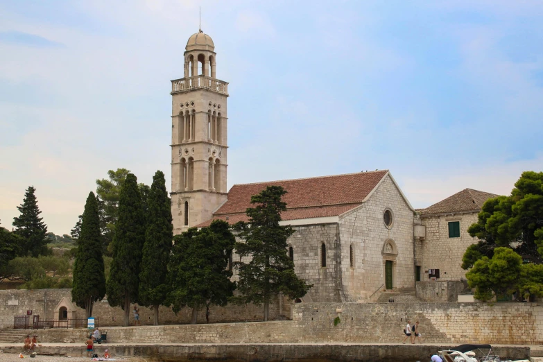 a large church with a bell tower next to a river