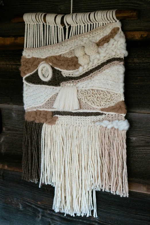 weavings being displayed on wooden surface with strings