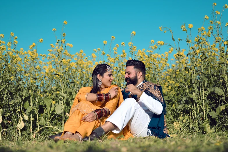 a young couple sits next to each other near flowers