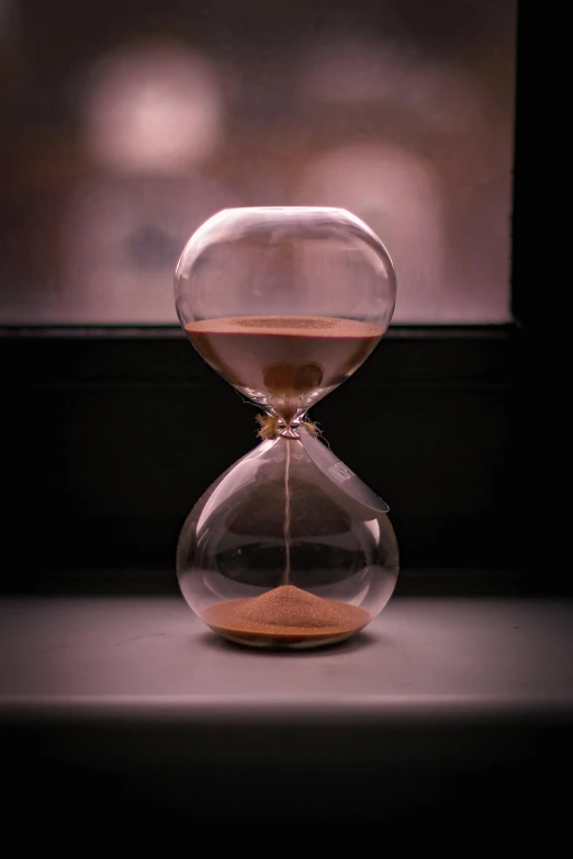 an empty hourglass is sitting on the window sill