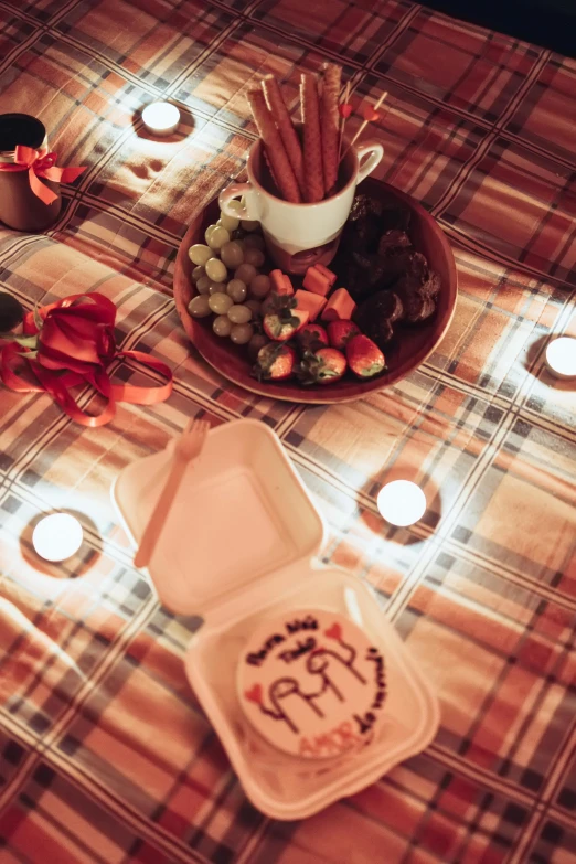 candles on a plaid table cloth are lit by votive candles