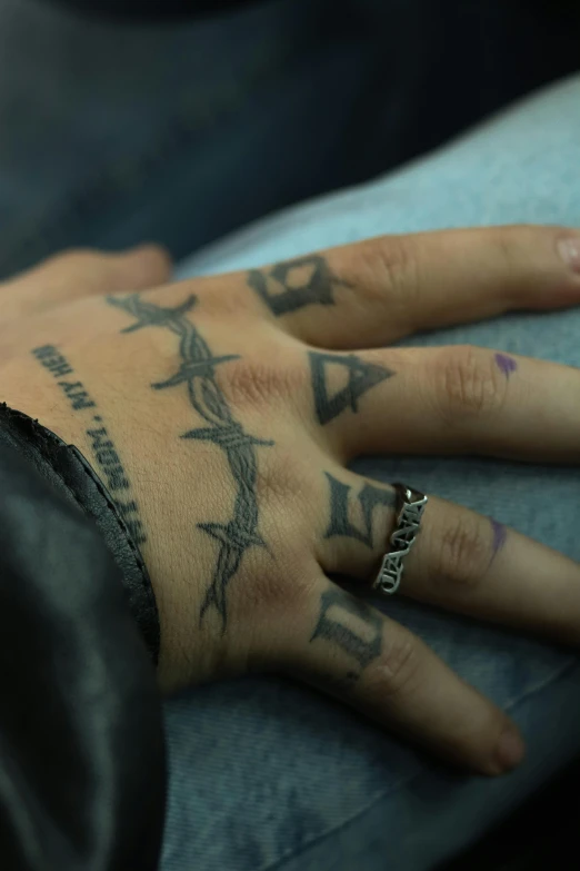 the hand of an individual has a cross tattoo on it