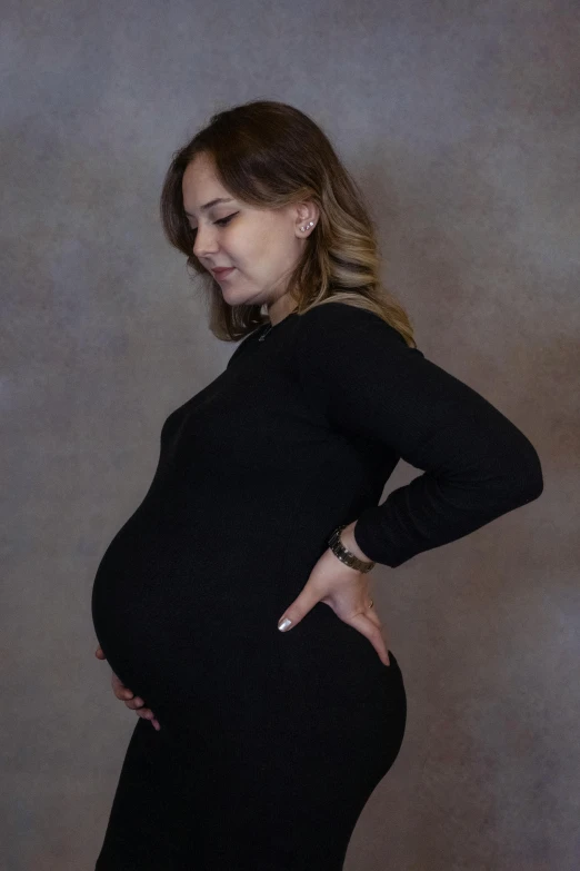 a pregnant woman posing with her stomach on her hips