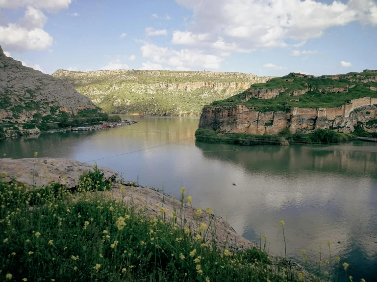 a small body of water surrounded by green mountains