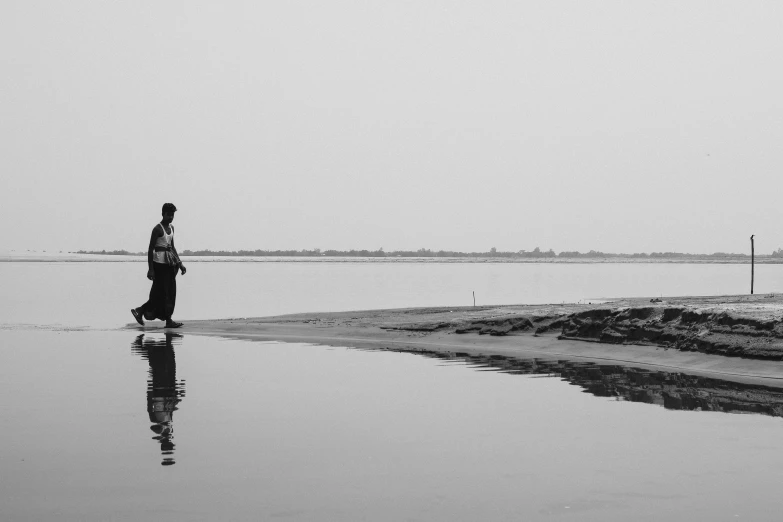 black and white po of a person standing near water