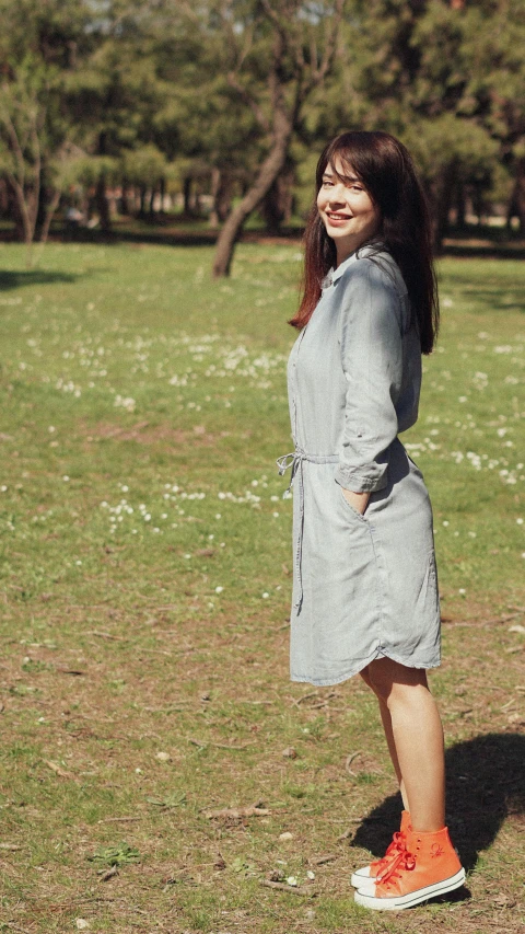 a young lady is wearing a dress in a field