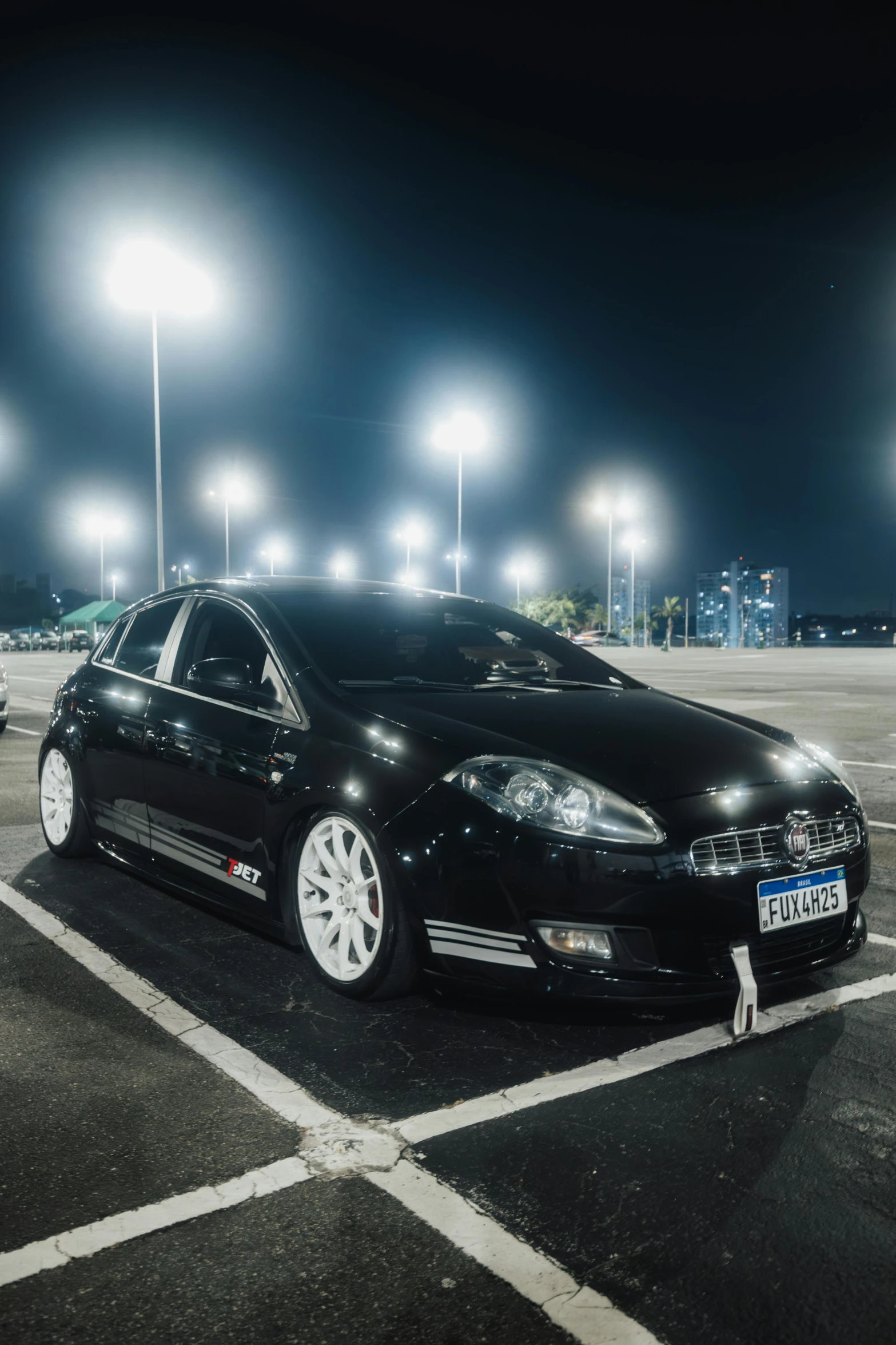 a black car parked in the middle of an empty lot