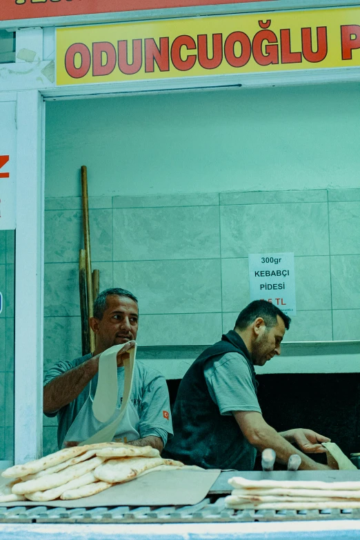 some men are making donuts at a doughnut shop