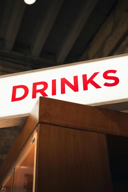 a wooden desk and sign with words drinks on it