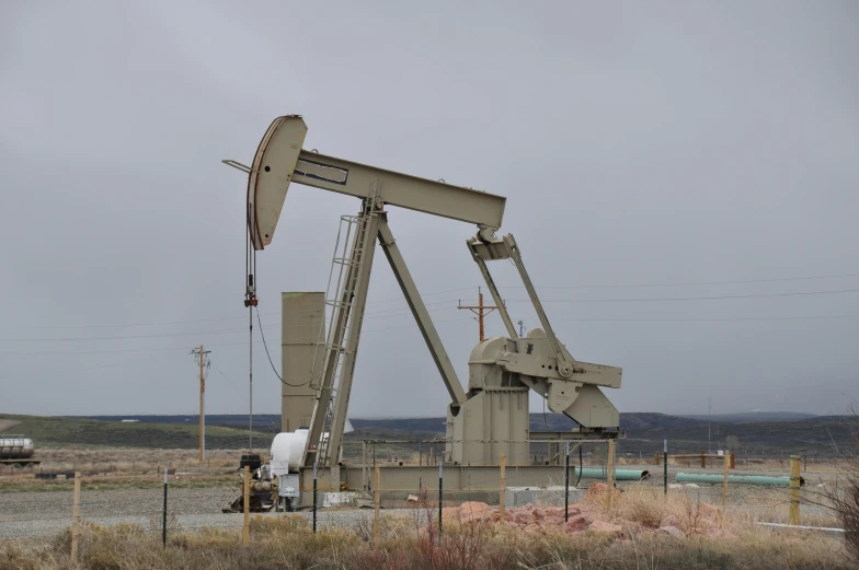 an oil pump sits on a dirt field