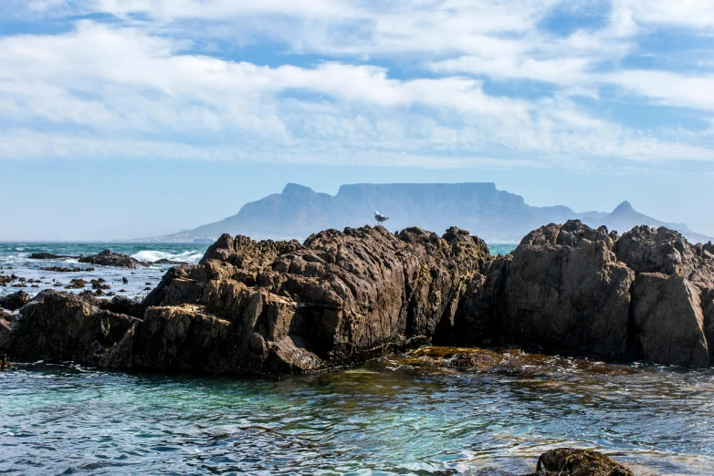 an ocean with a large rock and some rocks