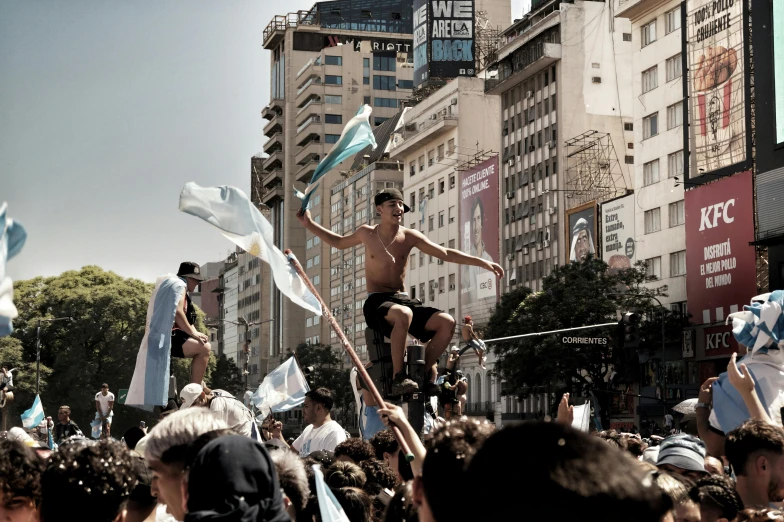 a man is balancing on his body surrounded by people in a crowd