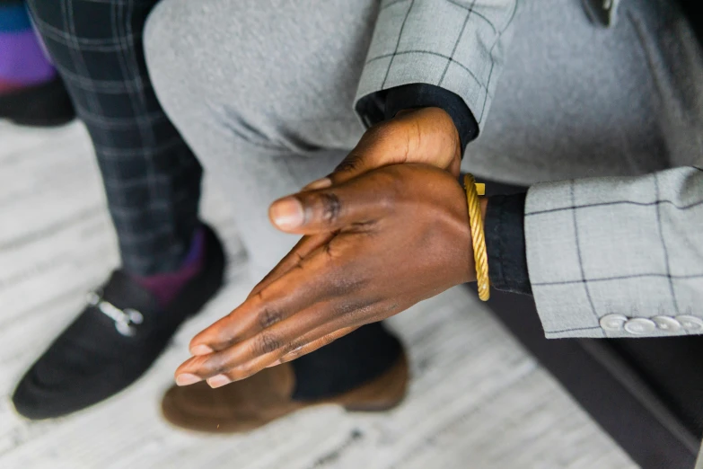 a person in a business suit sitting down holding their hands out