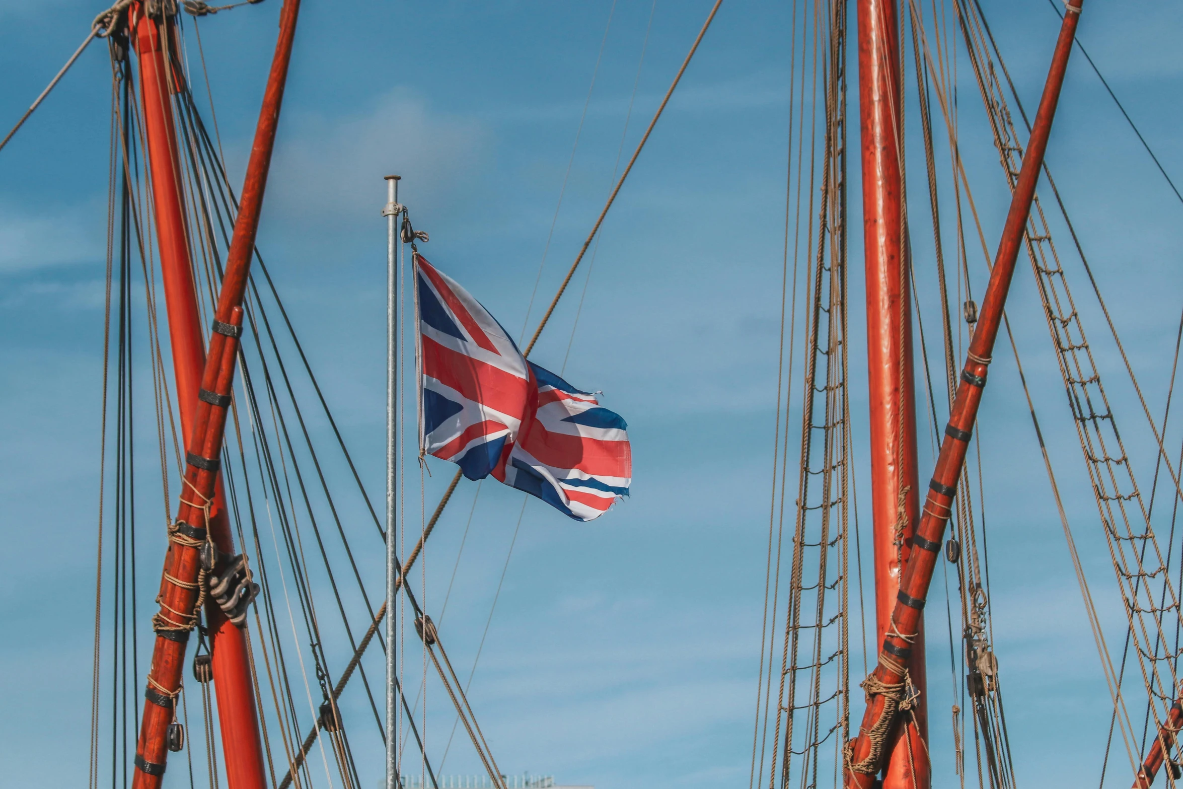 the british flag is attached to a tall ship