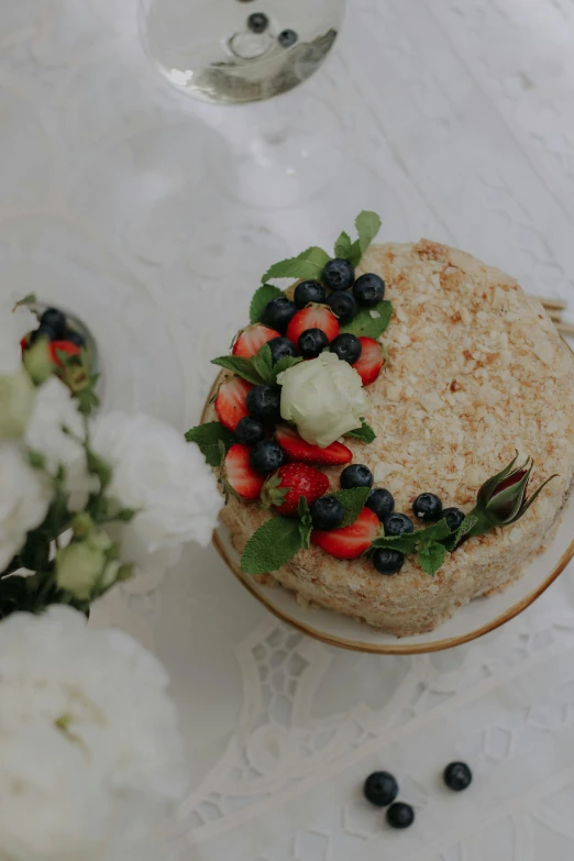 a cake is on a plate that has berries and other fruits