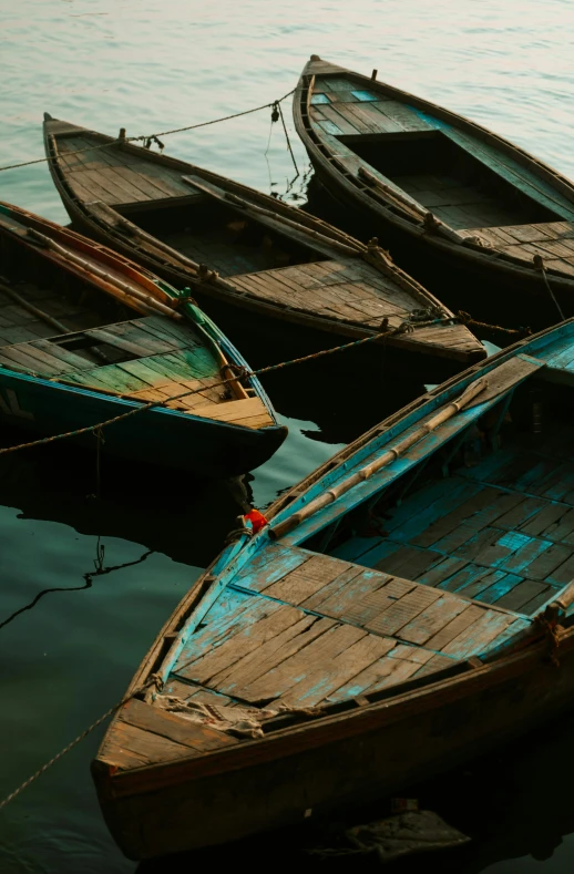 several small boats tied to a wooden post near the ocean