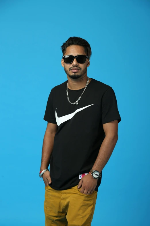 a man wearing a nike shirt and sunglasses posing