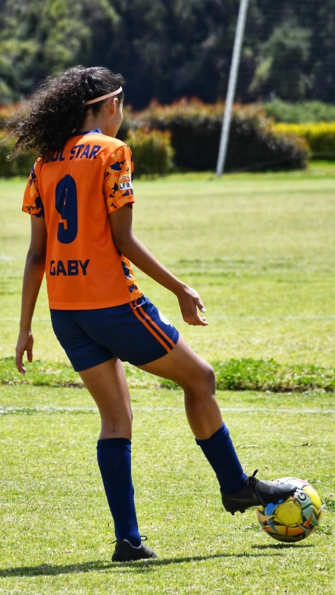 a girl that is on the grass with a soccer ball