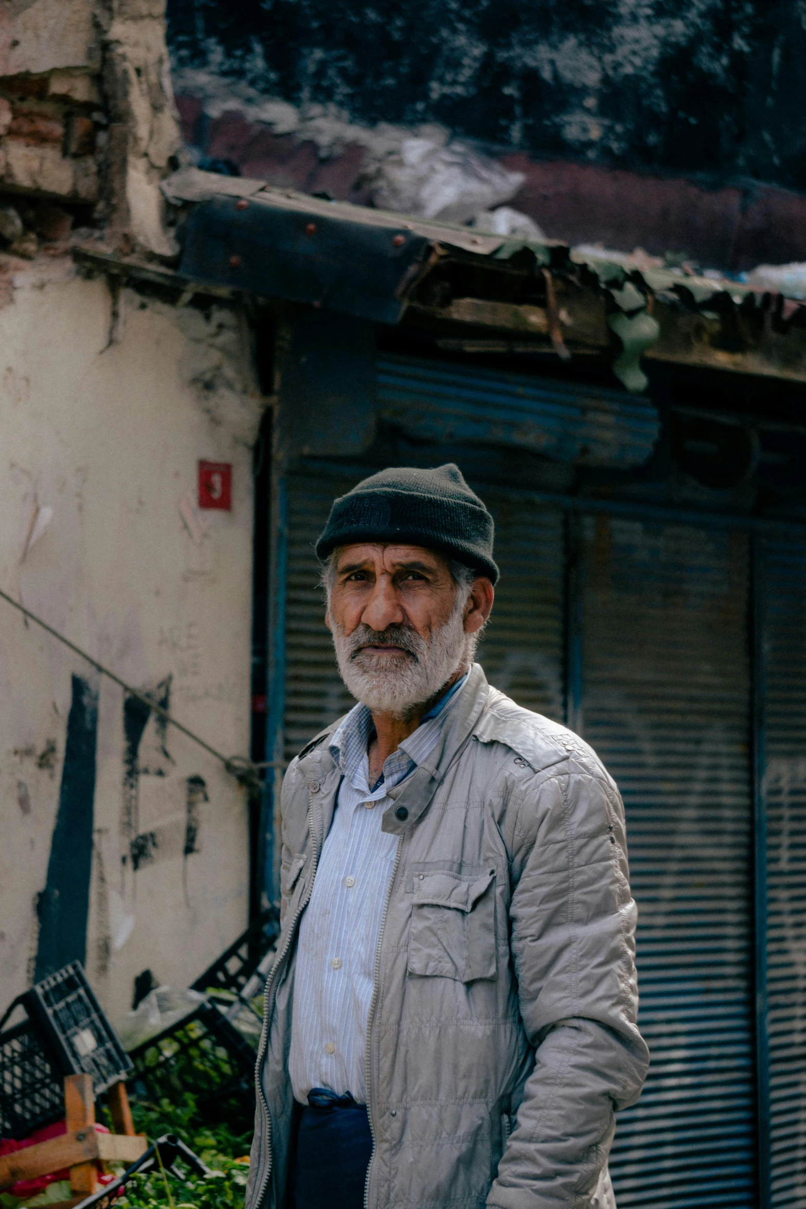 an old man is standing near a run down building