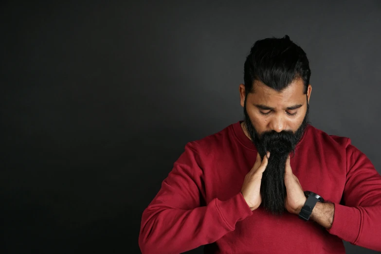 a man in a red shirt holds his hands to his mouth