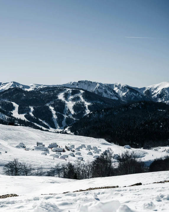 a view of snow covered mountains and valleys