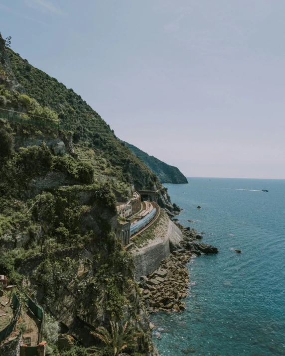 a train on the edge of a cliff next to the ocean