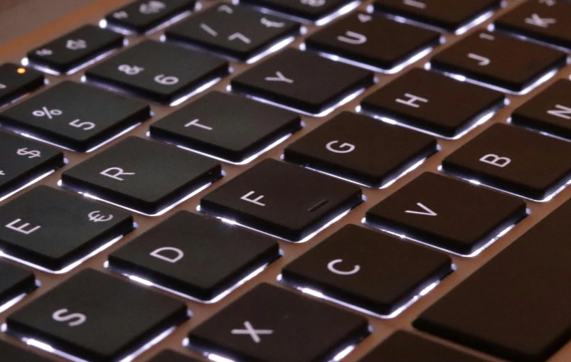 a keyboard has a dark colored backlited key board