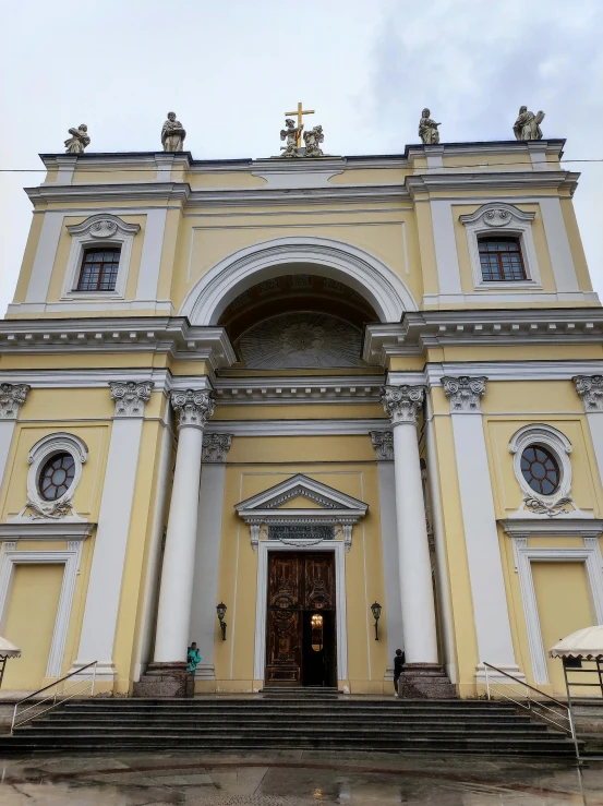 a large yellow and white building with pillars