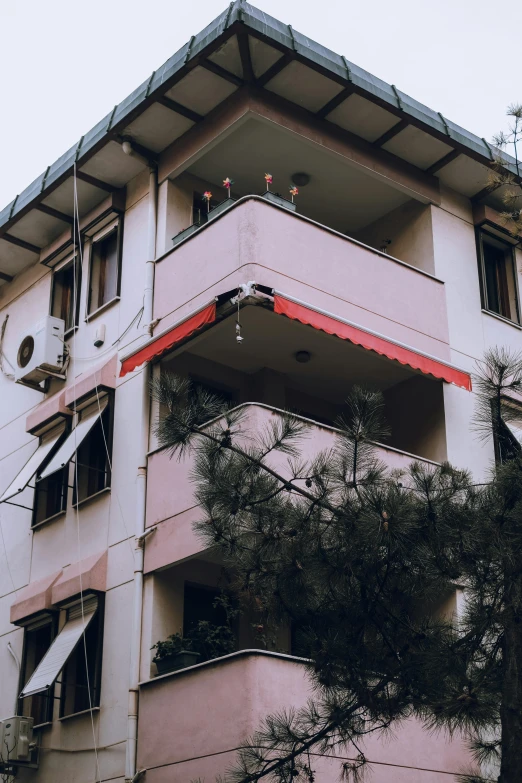 a tall pink and white building with a red flag