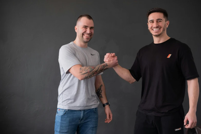 two men wearing black shirts are posing for the camera