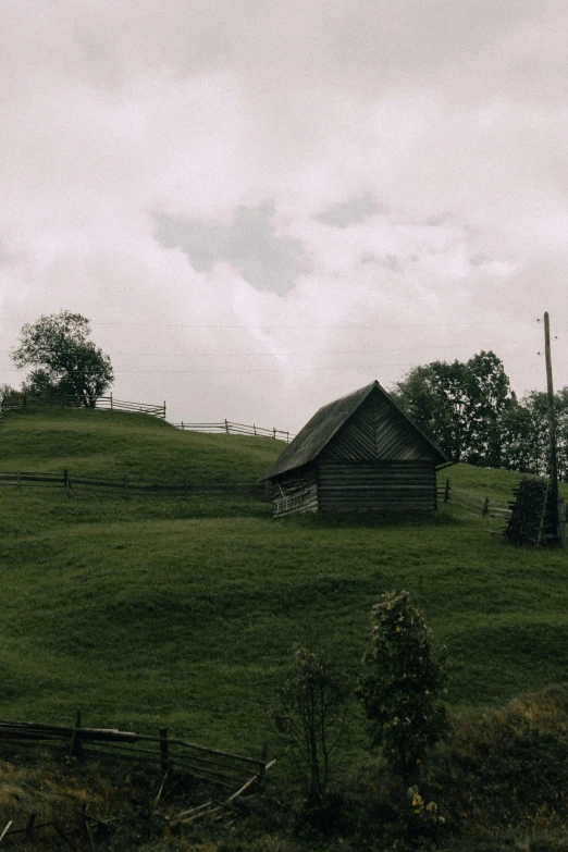 a small wooden house on a grassy hill