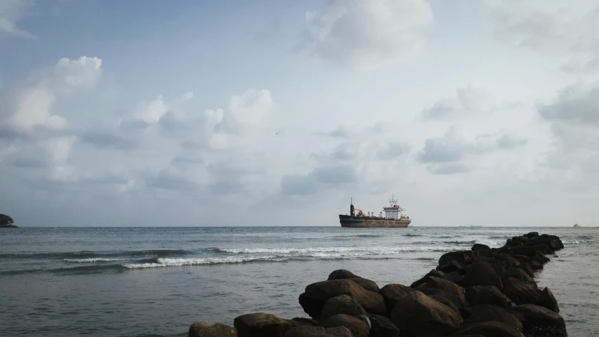 a boat traveling into the ocean, near rocks