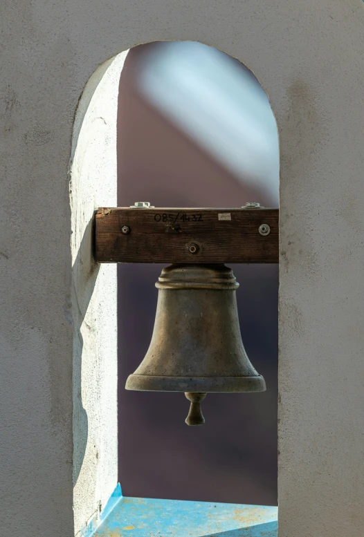 a bell hanging from a door frame next to a window