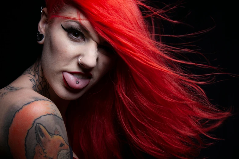 a lady with red hair and piercings looking to her left
