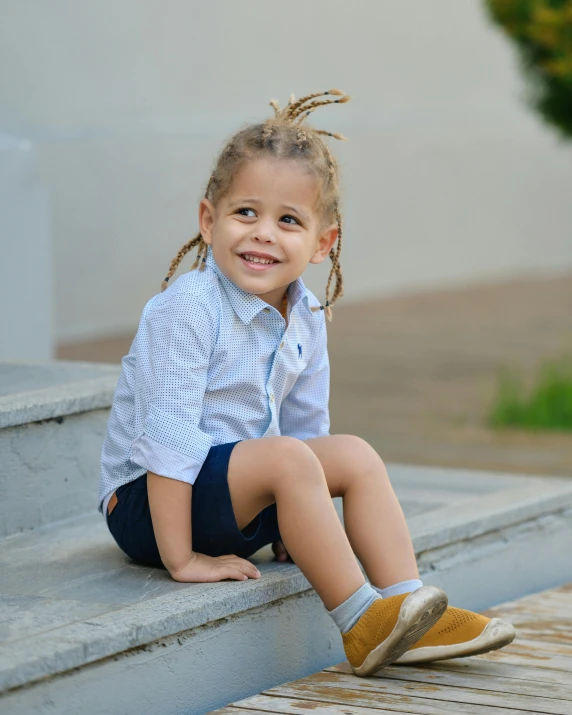 the little girl is posing on the stairs in her shoes