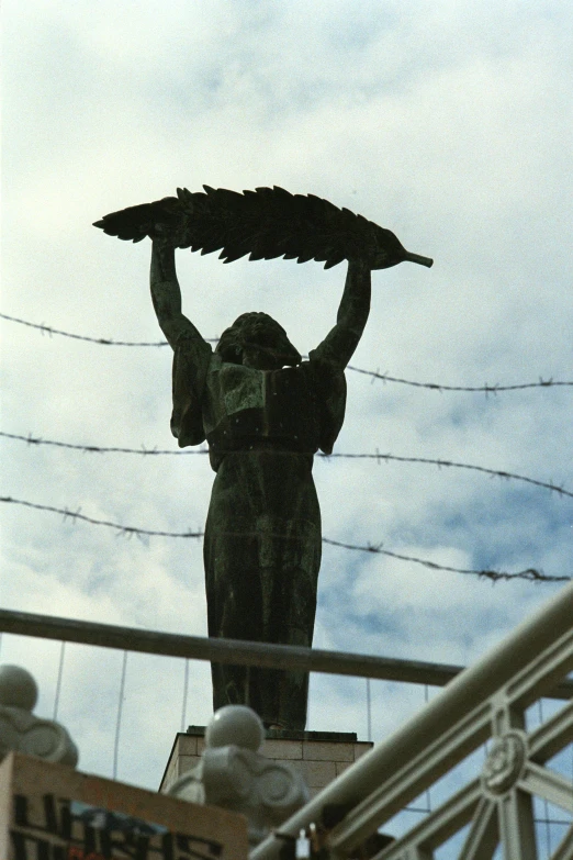 a statue of a woman holds a basket above her head