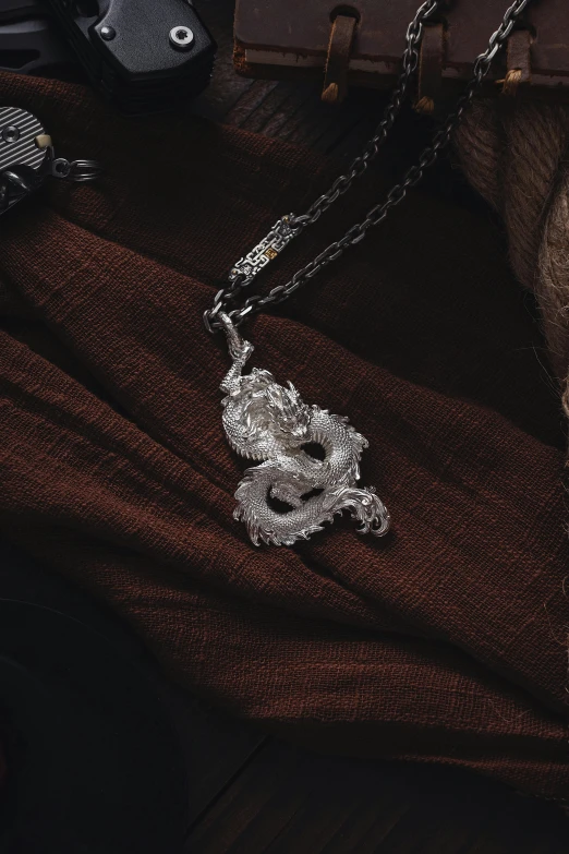 this is a silver snake pendant on the neck of a man