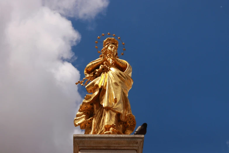 statue of lady liberty surrounded by gold flowers and a blue sky