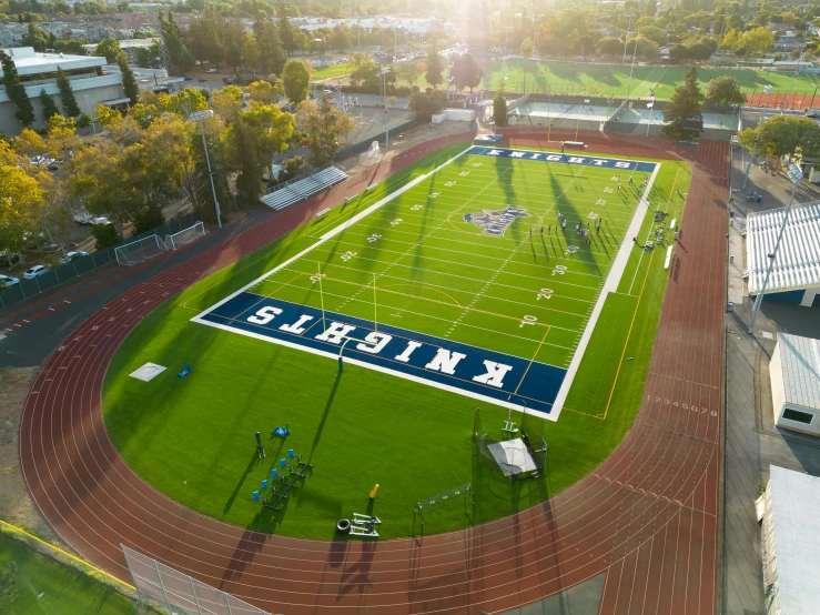 an aerial view of a sports field with a giant score board