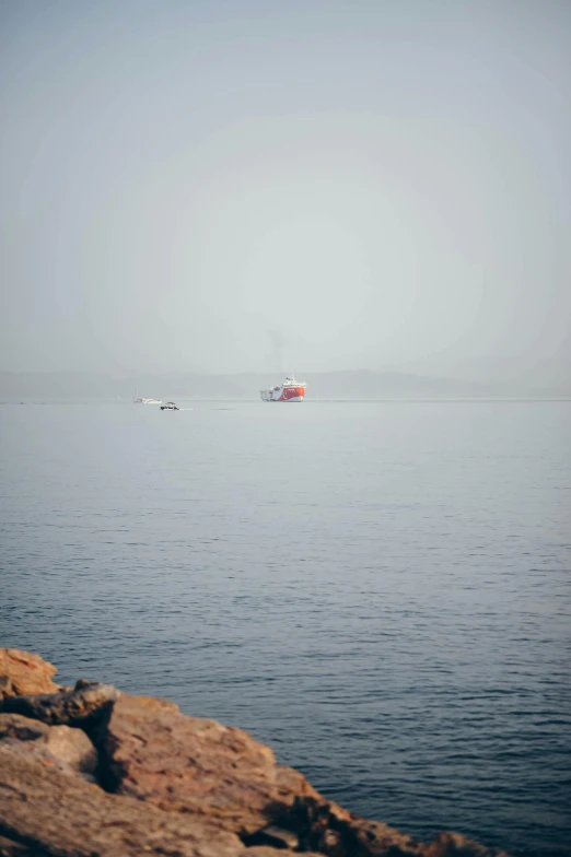 some small boats on water with mountains in the background