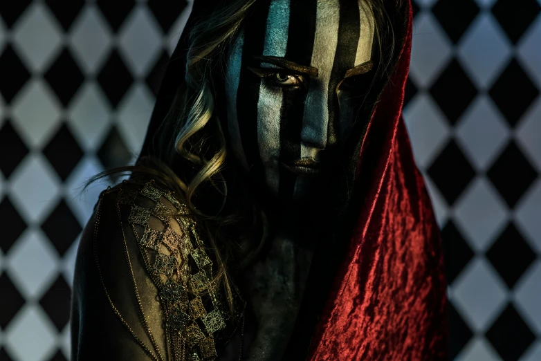 a woman with dark makeup and red veil