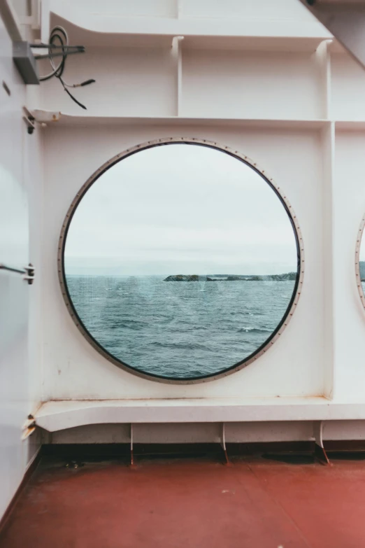 the porthole of a vessel with a circle mirror above it