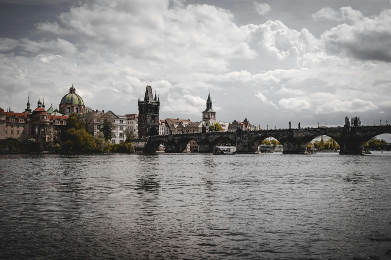 bridge on the water with stone architecture in background