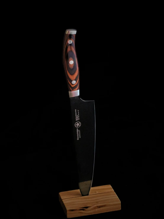 an unusual knife sits on a piece of wood