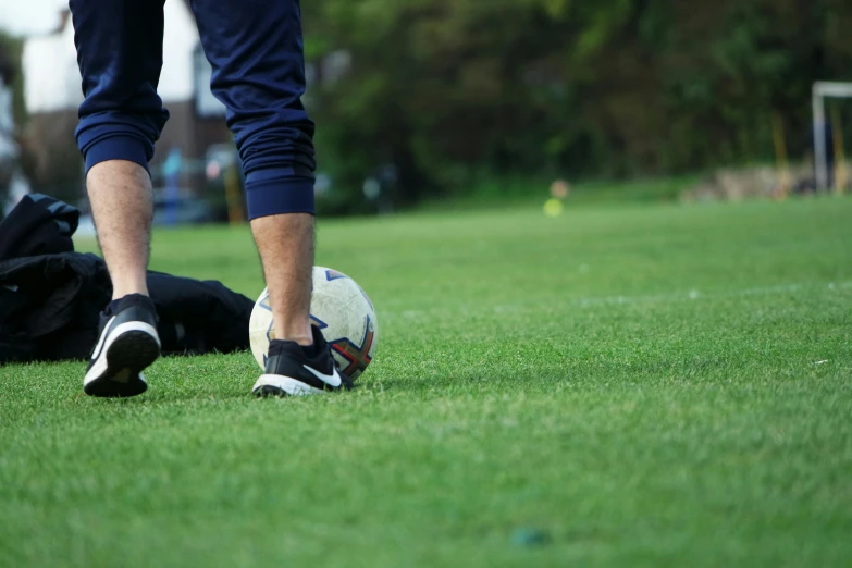 a person on a grass field with his foot resting on a soccer ball