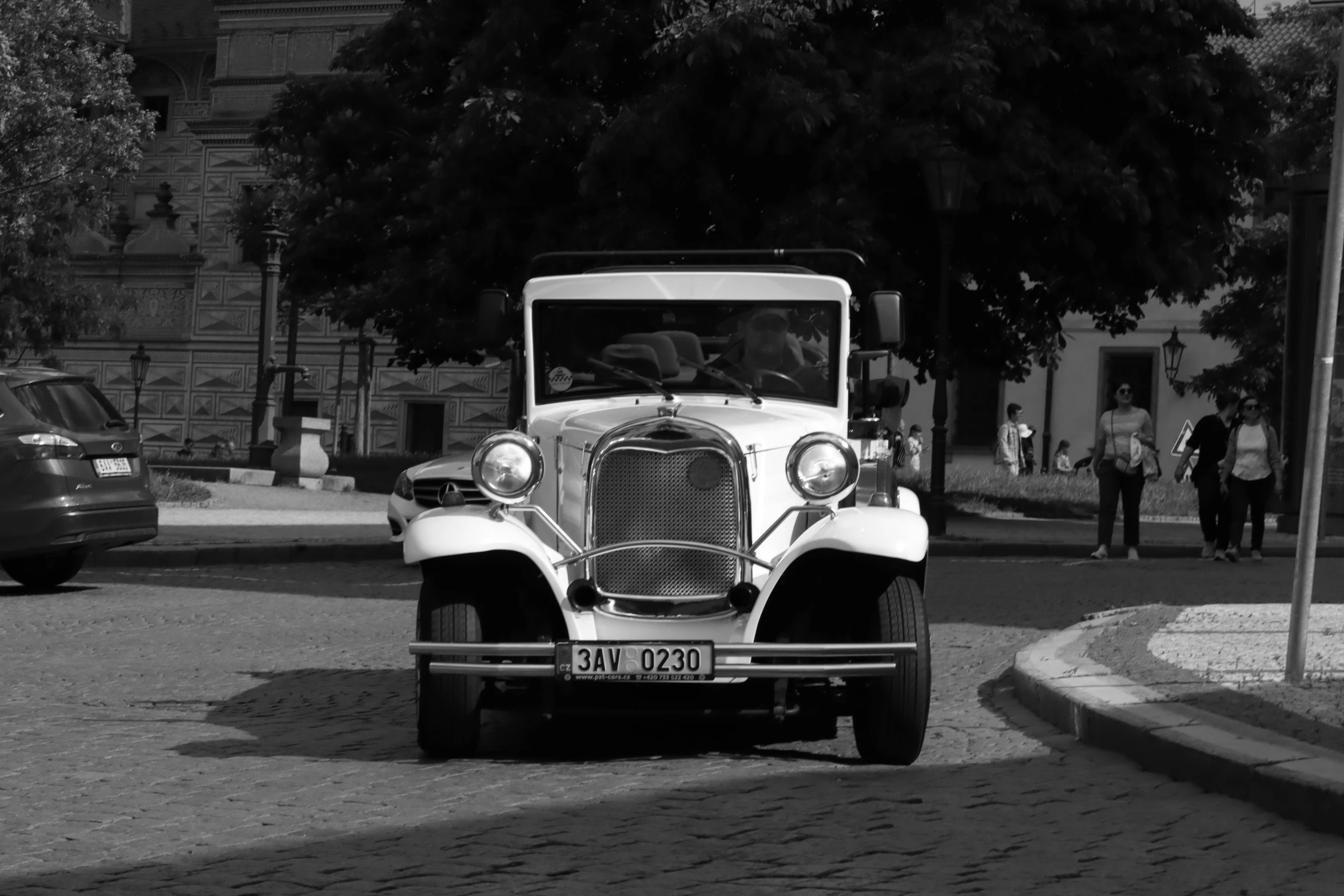 an old - fashioned automobile on the road on a sunny day