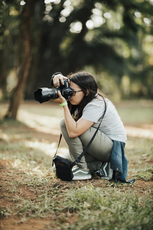 a woman kneeling down taking pictures on her camera